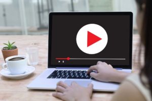 woman uploading video to youtube on computer