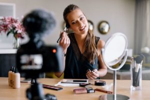 Woman making a video makeup tutorial in front of camera for YouTube Channel